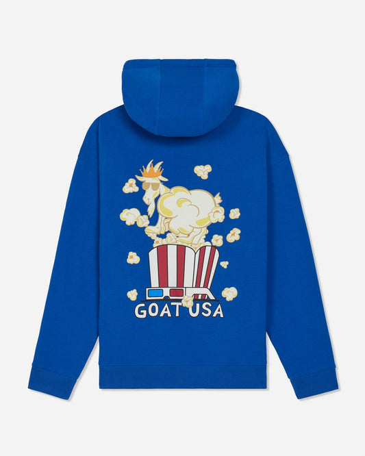 A royal blue hoodie shown from the back, featuring a graphic of a goat wearing a crown sitting in a red-and-white striped popcorn bucket with floating popcorn kernels and the text 'GOAT USA' below.