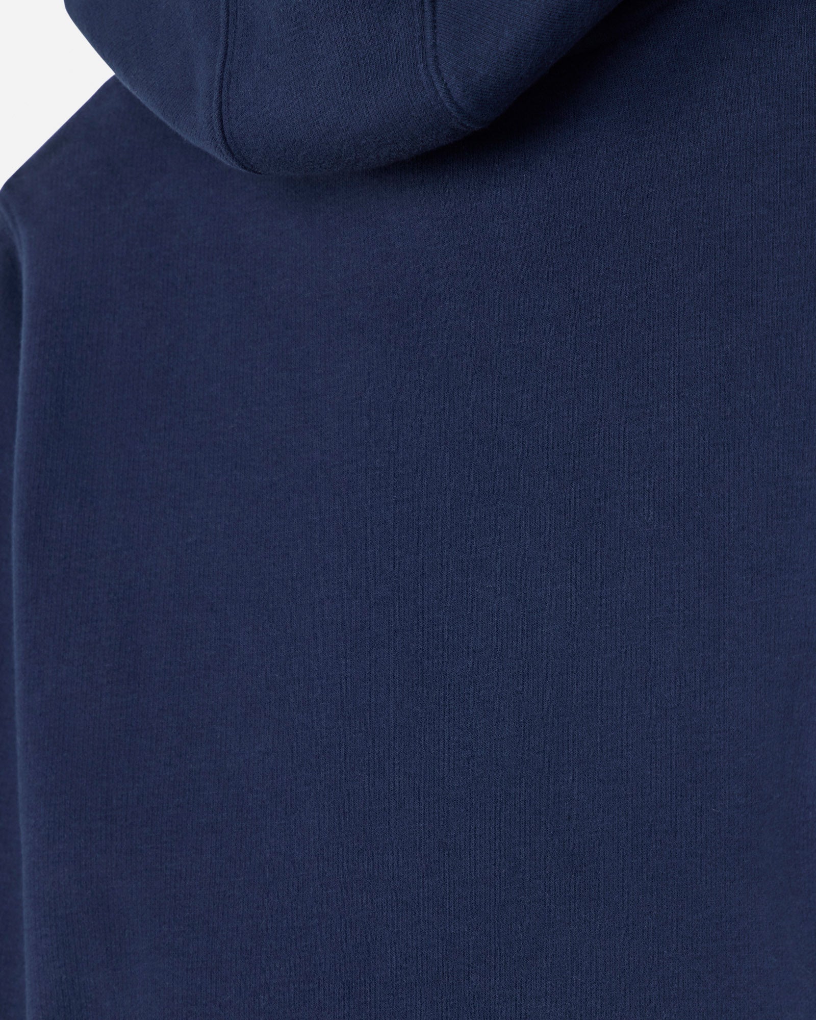 Close-up of a navy blue hooded sweatshirt showing the fabric texture and hood seam.
