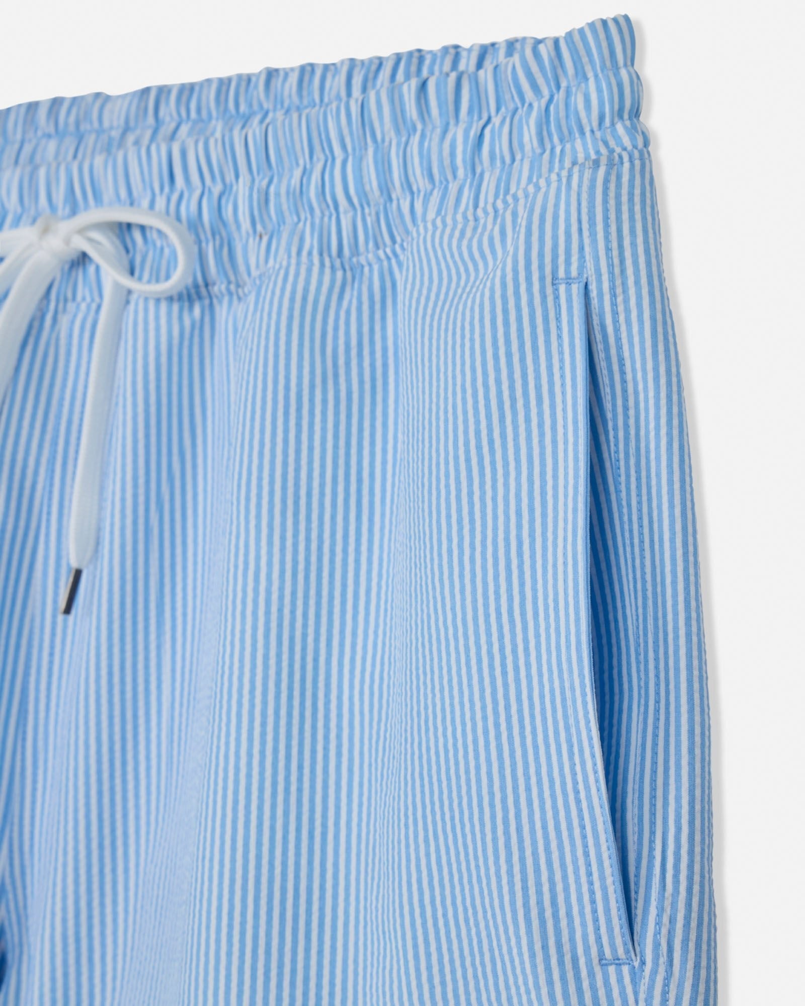 Close-up of blue and white striped shorts with a drawstring on a white background
