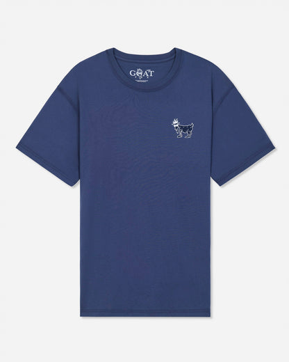 A blue short-sleeve t-shirt with a small white goat logo on the left chest and a white 'GOAT' brand print inside the collar, shown on a light gray background.#color_navy