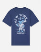 A navy blue short-sleeve t-shirt with a large graphic on the back featuring a light blue cartoon goat baseball player, the text 'NEW YORK' arched above, and 'GOAT USA' below.
