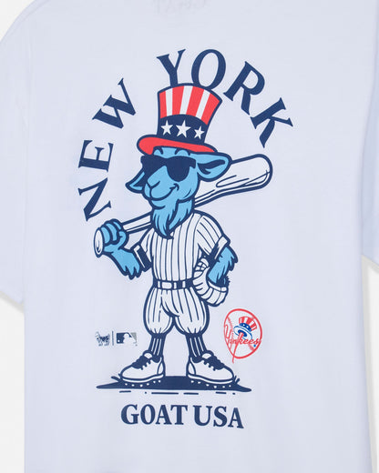 White short-sleeve t-shirt featuring a blue cartoon goat mascot in a baseball uniform with a red, white, and blue top hat. The graphic includes the text 'NEW YORK' arched above and 'GOAT USA' below, with MLB and New York Yankees logos near the bottom.#color_white