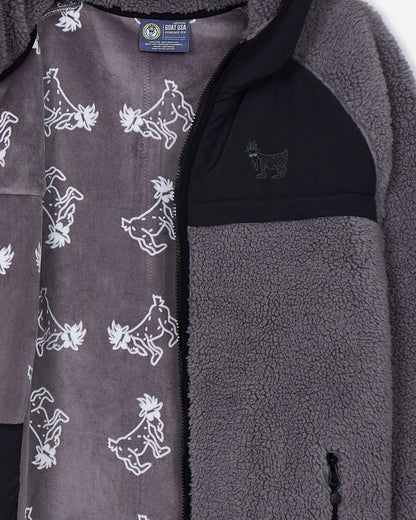 Close-up of a gray fleece jacket with goat pattern and brand label.#color_gray