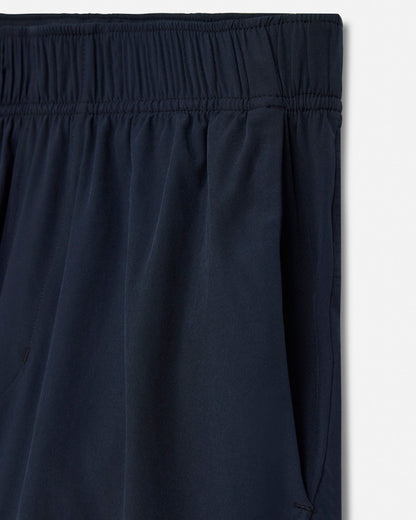 Close-up of black pants with an elastic waistband on a light gray background#color_black