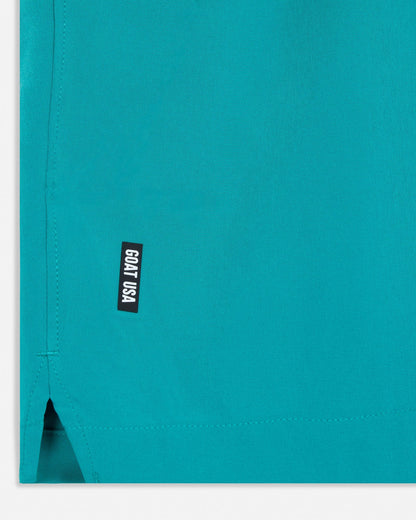 Teal shorts with a small black label on a white background#color_jade