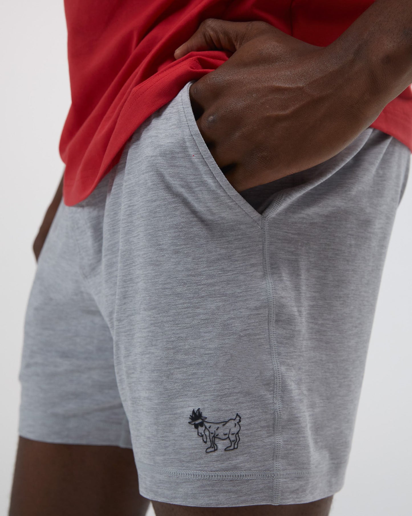 Person wearing gray shorts with a small logo on a plain background#color_space-dye-gray