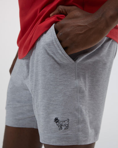 Person wearing gray shorts with a small logo on a plain background#color_space-dye-gray