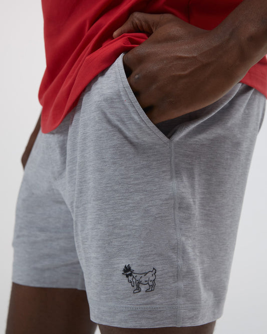 Person wearing gray shorts with a small logo on a plain background#color_space-dye-gray