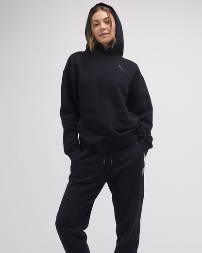 Person wearing a black hoodie and pants on a white background#color_black