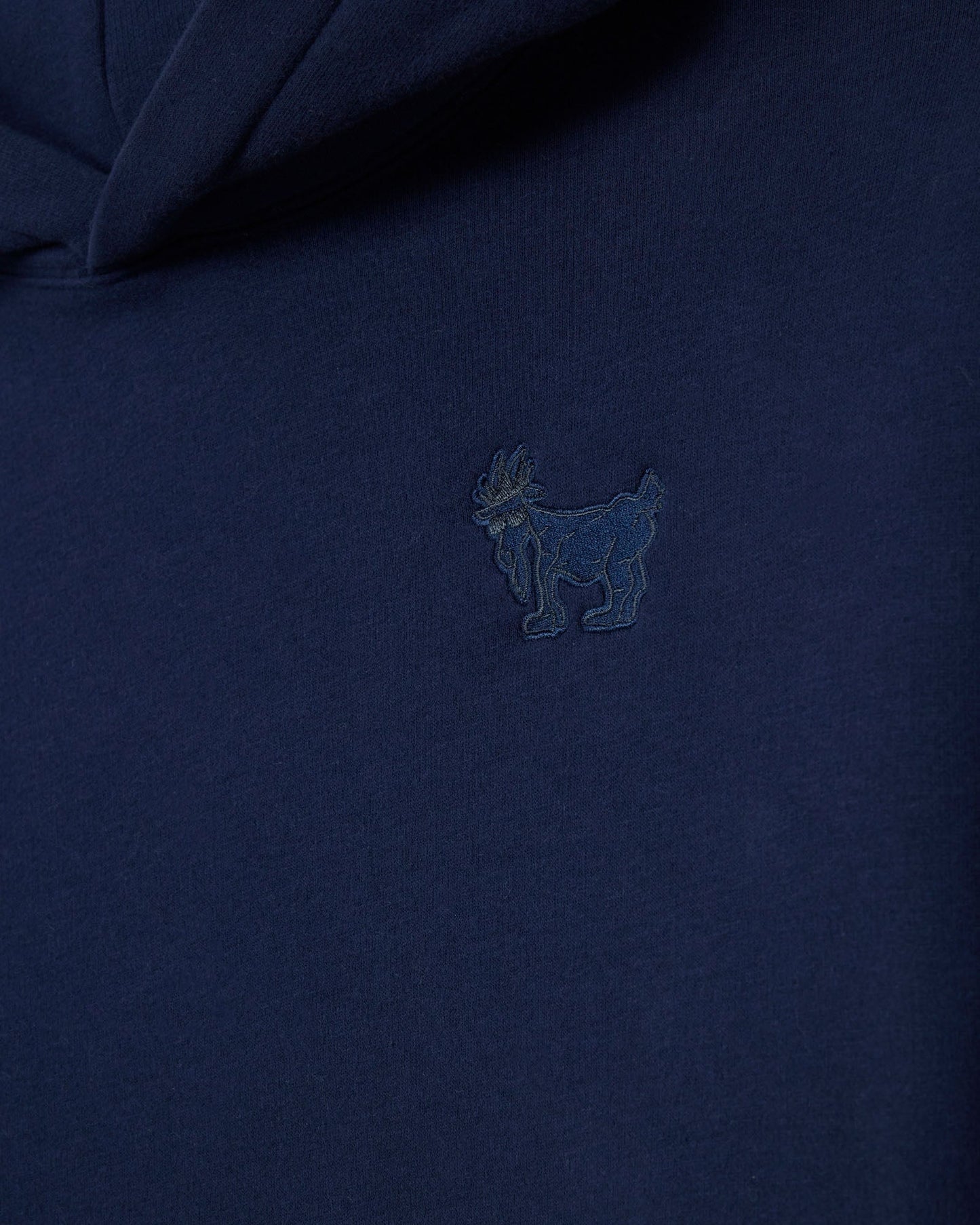 Navy blue polo shirt with a small embroidered logo on the chest.#color_navy-blazer