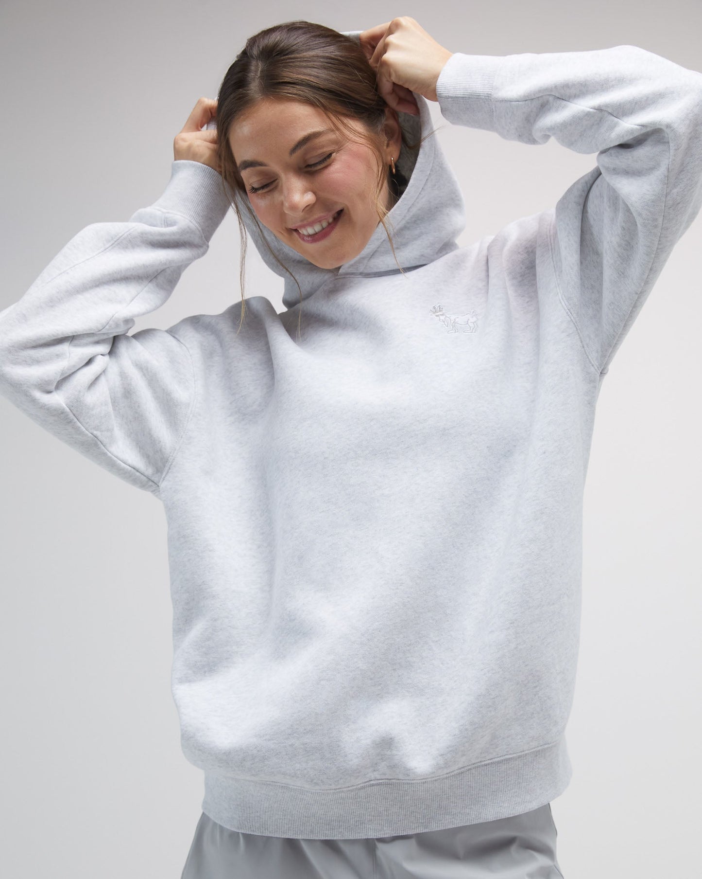 Person wearing a light gray hoodie on a plain background#color_pale-gray