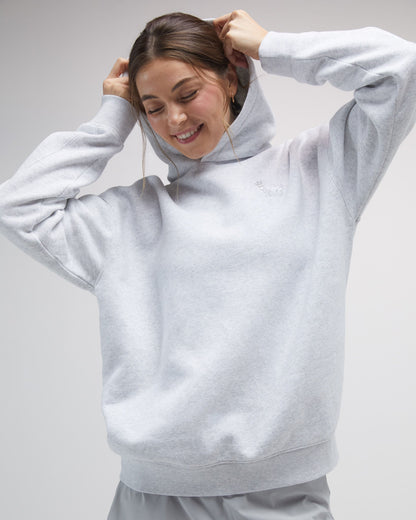 Person wearing a light gray hoodie on a plain background#color_pale-gray