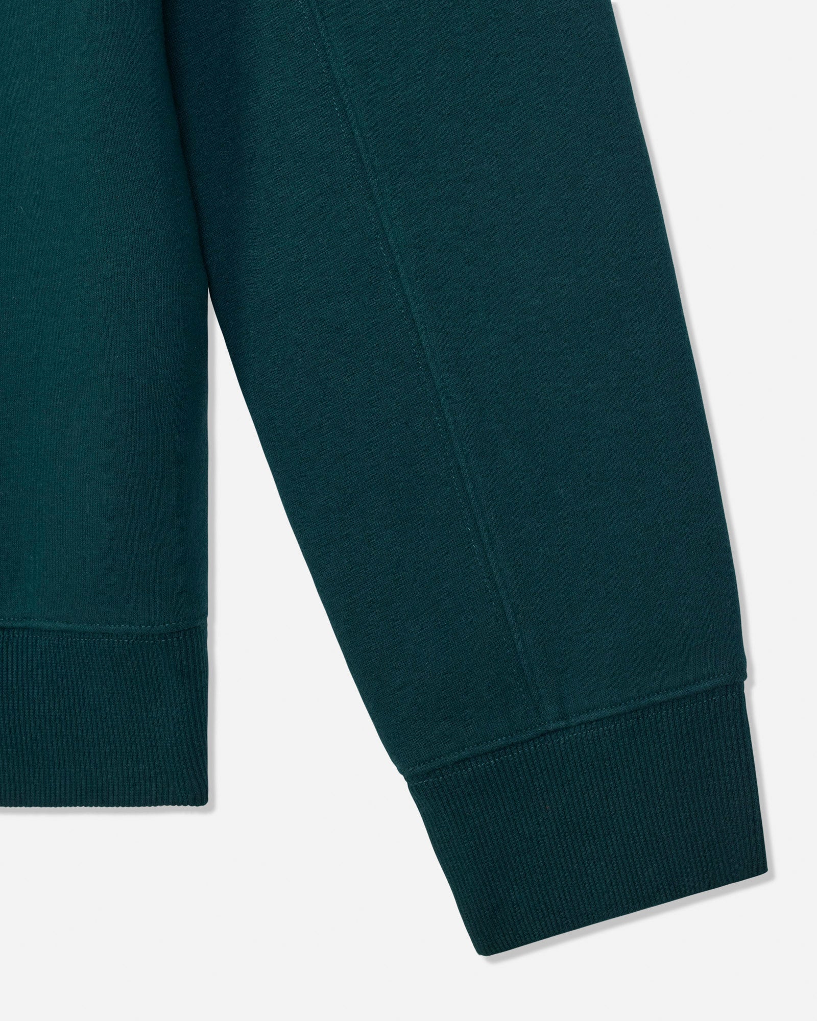 Close-up of a dark teal green sweatshirt sleeve showing the ribbed cuff and body fabric against a light gray background.#color_sage