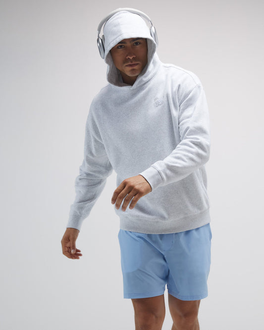 Person wearing a light gray hoodie and blue shorts on a plain background#color_pale-gray