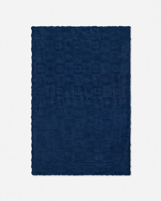 A dark navy blue rectangular blanket with a textured, embossed checkerboard pattern and fringed edges, shown flat against a light gray background.