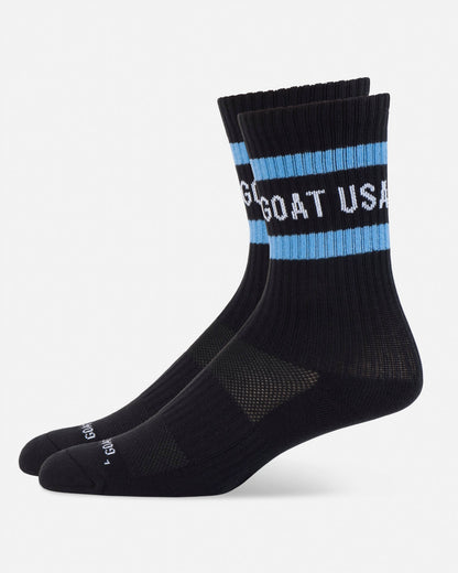 Black socks with blue stripes and 'GOAT USA' text on a white background