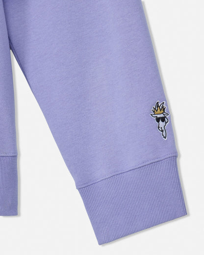 Close-up of a purple sweatshirt sleeve with a small embroidered design on a white background#color_periwinkle