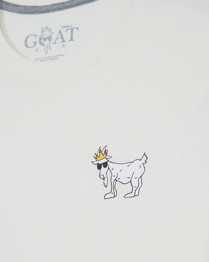 Close-up of a white t-shirt showing the inner neck label with 'GOAT' branding and a small graphic of a goat wearing sunglasses and a crown printed on the chest.#color_bone