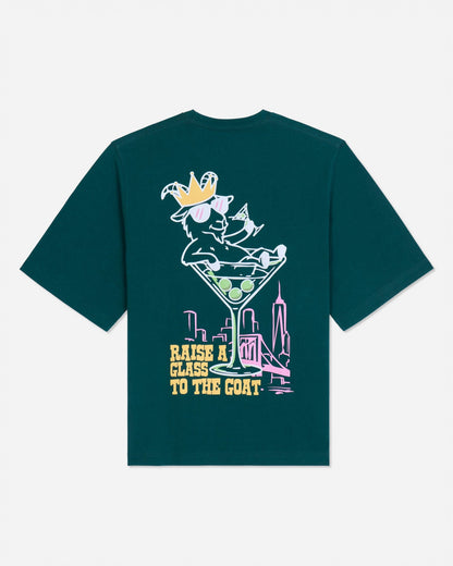 Back of sage t-shirt with martini glass goat graphic and text that reads 'Raise a glass to the GOAT'