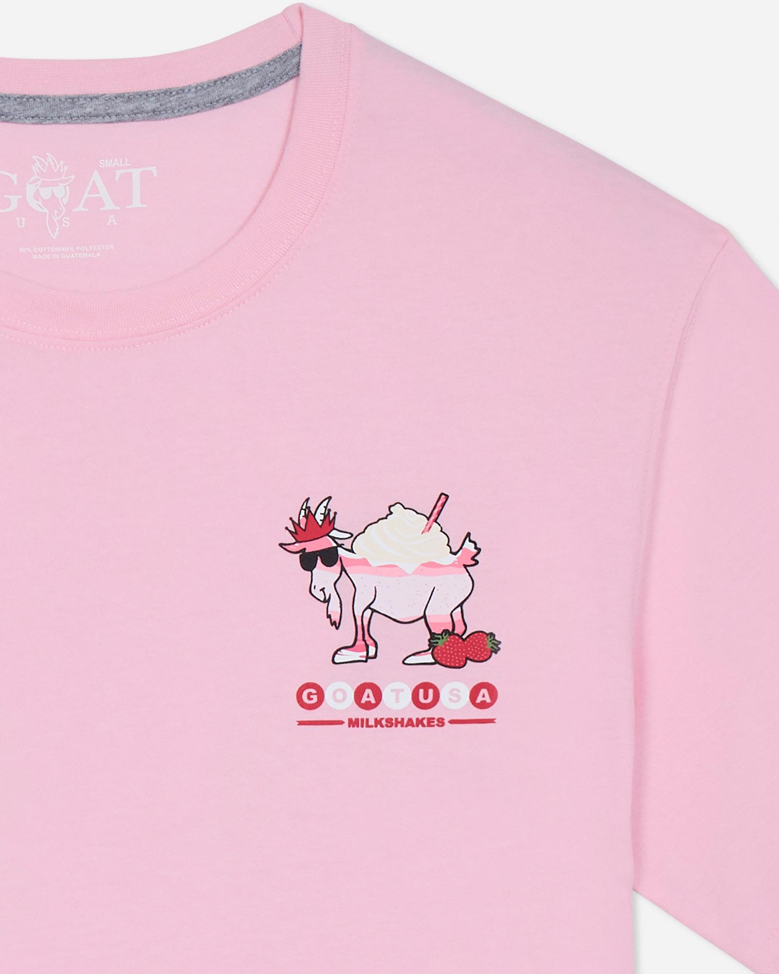 Pink t-shirt with a cartoon goat design and branding on a light gray background.