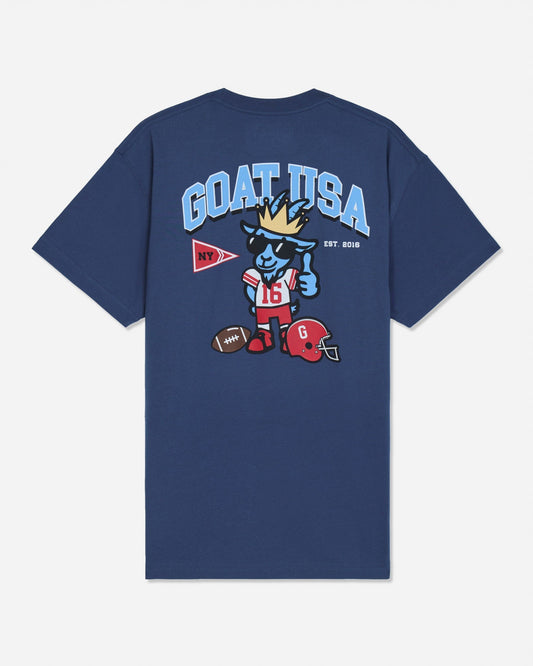 A navy blue short-sleeve t-shirt with a large graphic on the back. The graphic features the text 'GOAT USA' in light blue, a cartoon goat mascot wearing a gold crown and sunglasses, a red football helmet, and a red and white pennant.
