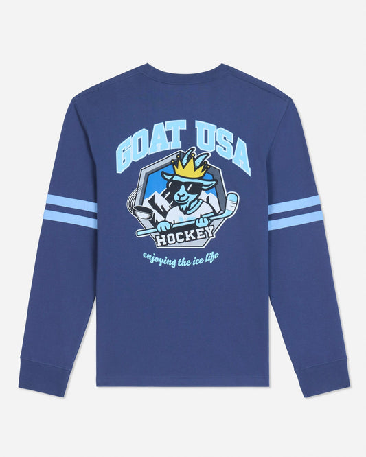 A royal blue long-sleeve t-shirt with a large graphic on the back featuring a cartoon goat hockey player and the text 'GOAT USA HOCKEY'. The sleeves have two light blue stripes, and the shirt is shown against a light gray background.