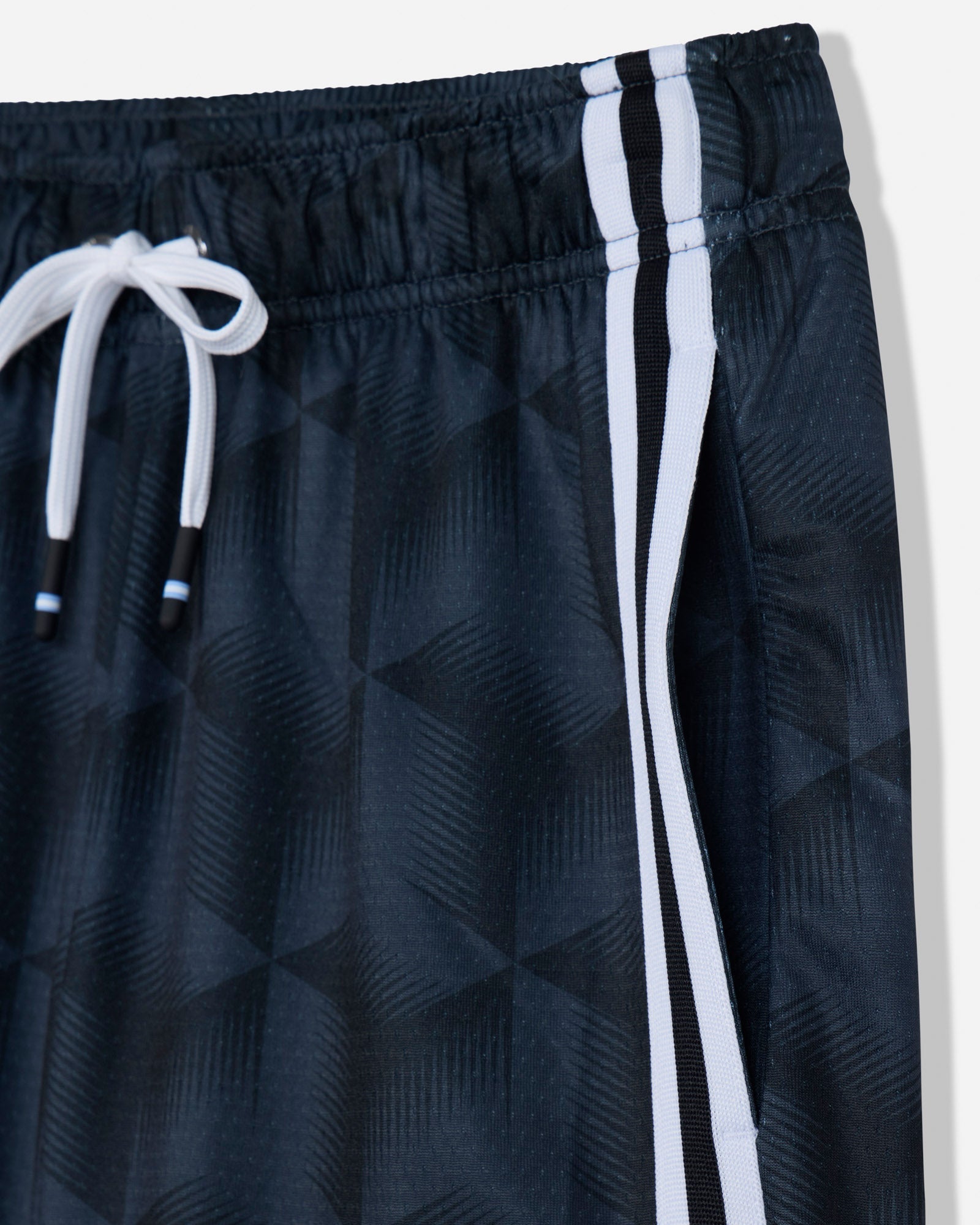 Close-up of dark athletic shorts with a subtle geometric pattern, featuring a white drawstring and two vertical white stripes along the side.#color_black