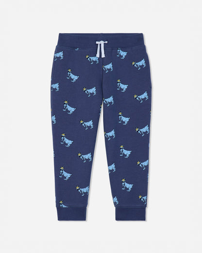 A pair of navy blue jogger pants featuring an all-over print of cartoon cows in light blue and yellow, with a white drawstring at the elastic waistband.#color_navy