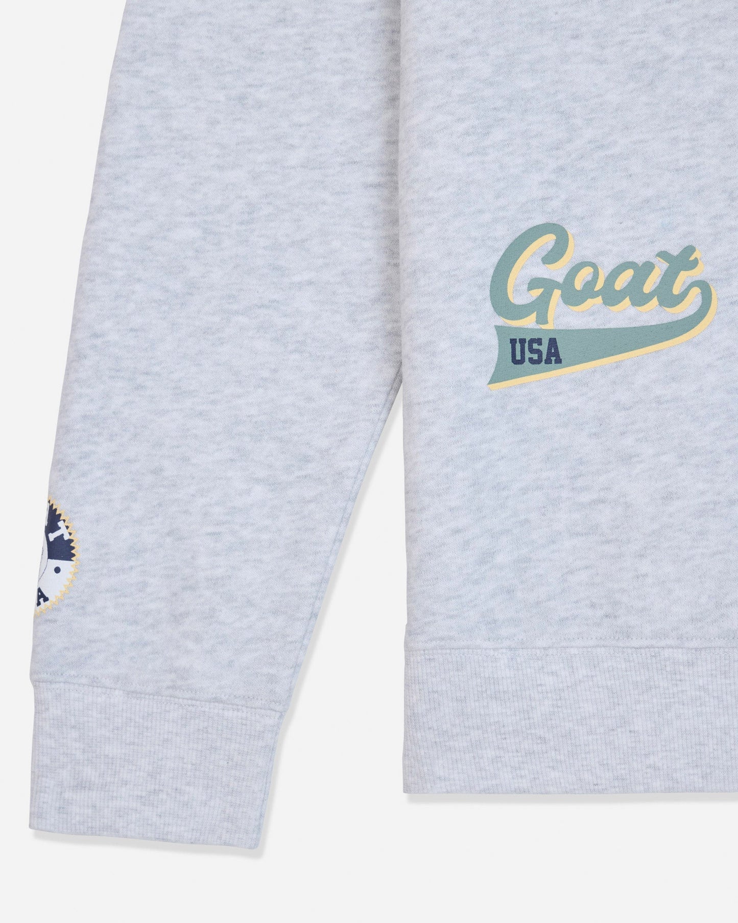 Sleeve of gray crewneck with patches