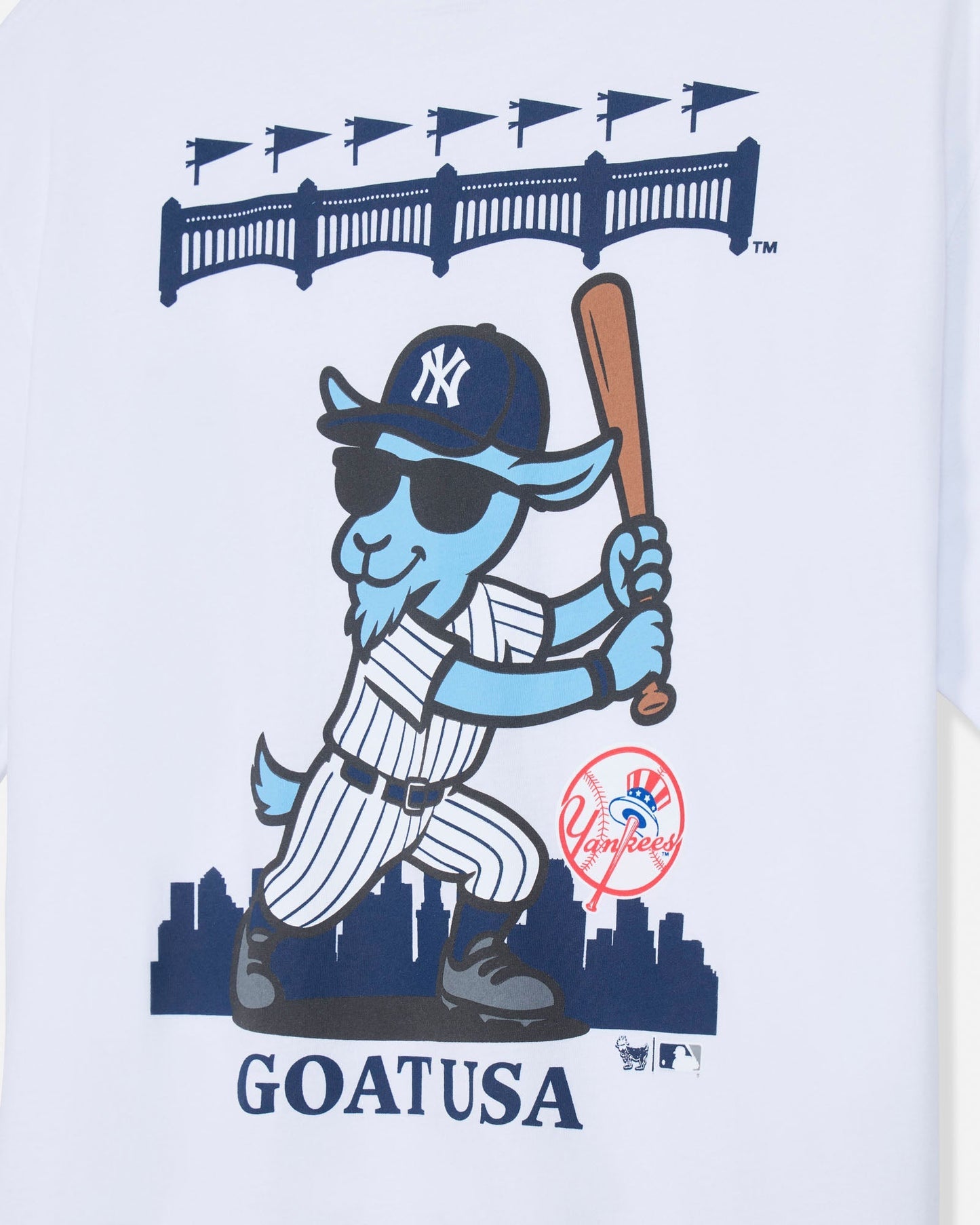 A close-up of a white graphic print featuring a cartoon blue goat in a New York Yankees baseball uniform, holding a bat, with the word 'GOAT USA' below and a red Yankees logo near the lower right of the character.#color_white