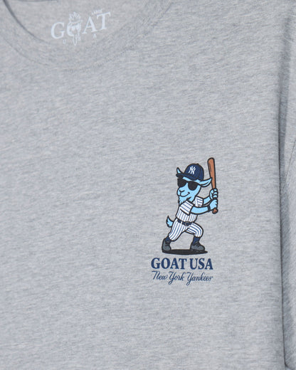 Close-up of a heather gray t-shirt featuring a graphic of a blue and white goat baseball player holding a bat, with 'GOAT USA New York Yankees' printed below.#color_gray