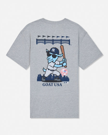 A heather gray short-sleeve t-shirt with a large graphic on the front featuring a cartoon blue goat in a New York Yankees uniform holding a bat, with 'GOAT USA' printed below.#color_gray