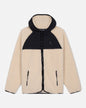 Two-tone sherpa jacket with beige front and black hood on a light gray background#color_sandshell